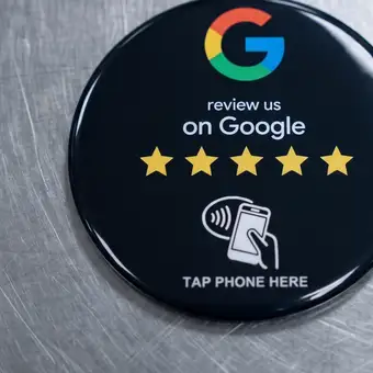 Erzeugte Ansicht: schwarze runde NFC-Plakette auf einer Arbeitsfläche aus gebürstetem Edelstahl