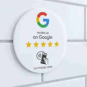Erzeugte Ansicht: weisse runde NFC-Plakette an einer weiss geflieste Wand neben einem Türgriff